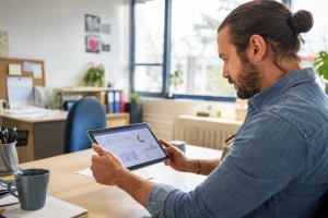 Éducateur spécialisé consultant le logiciel Airmes sur une tablette dans un établissement médico-social